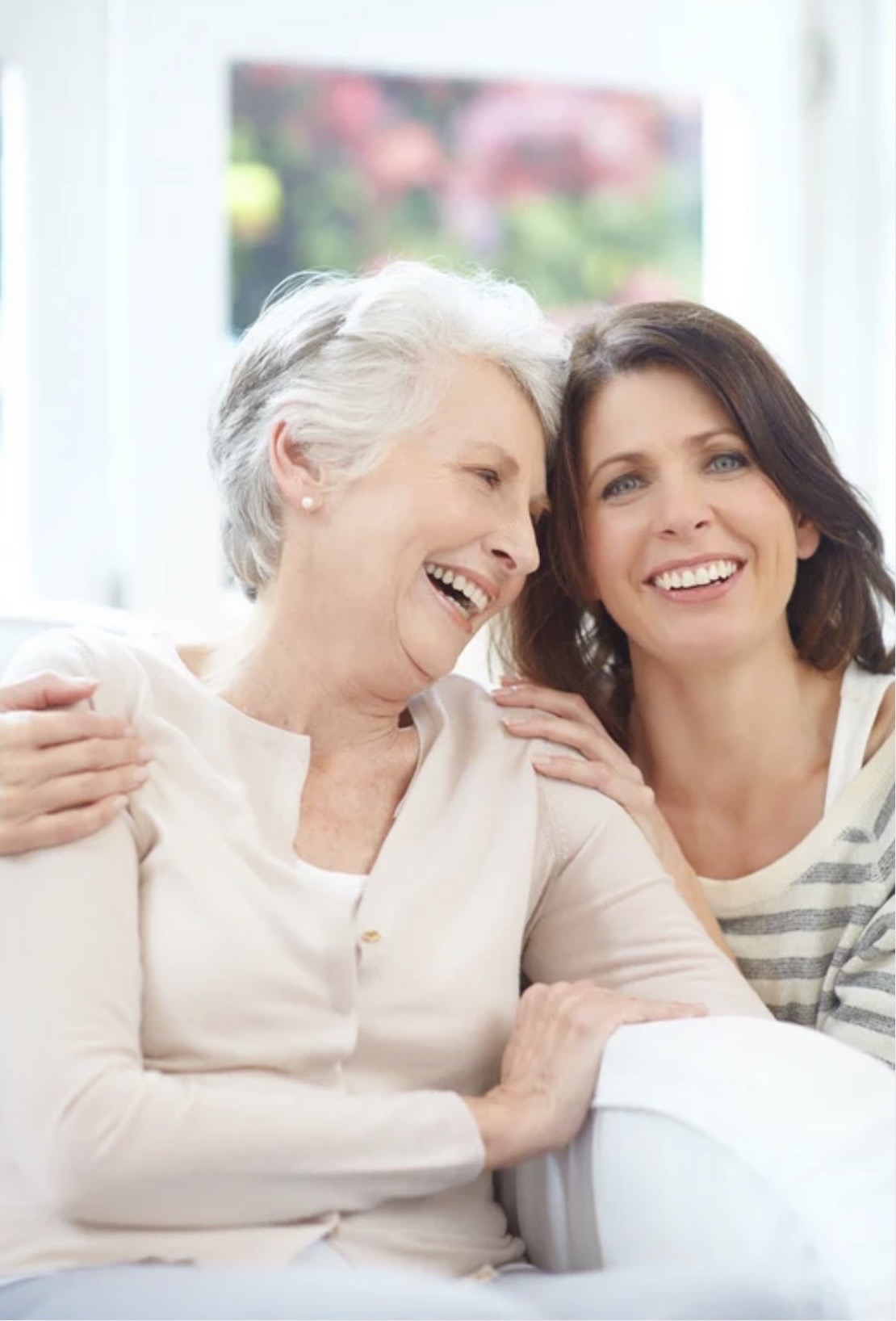 Adult daughter warmly hugging her elderly mother